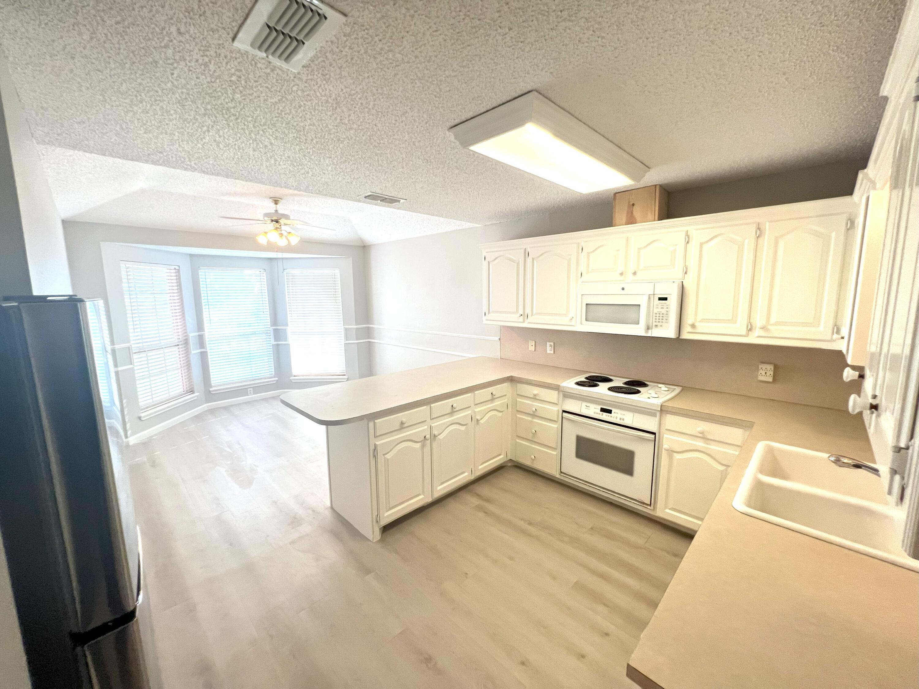 2314 Farm To Market 41 Lubbock, TX 79423 - Photo 11 of 18 a large white kitchen with a window wooden floor and stainless steel appliances