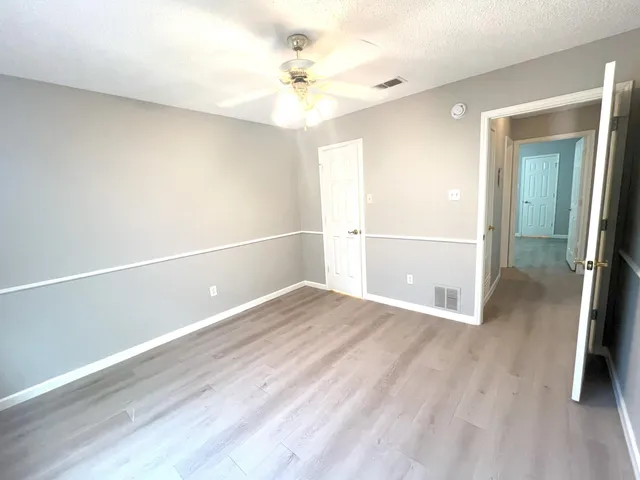 a view of an empty room with wooden floor