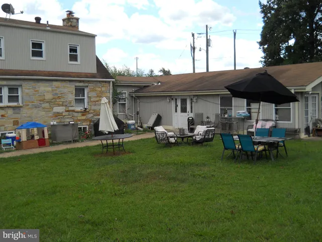 a view of a house with backyard sitting area and garden