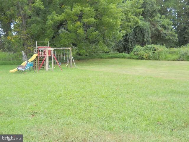 a view of a yard with a slide and a bench