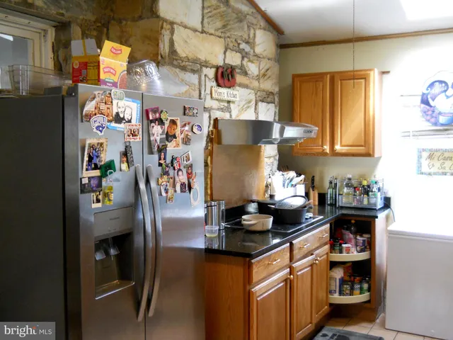 a kitchen with stainless steel appliances granite countertop a refrigerator and a stove