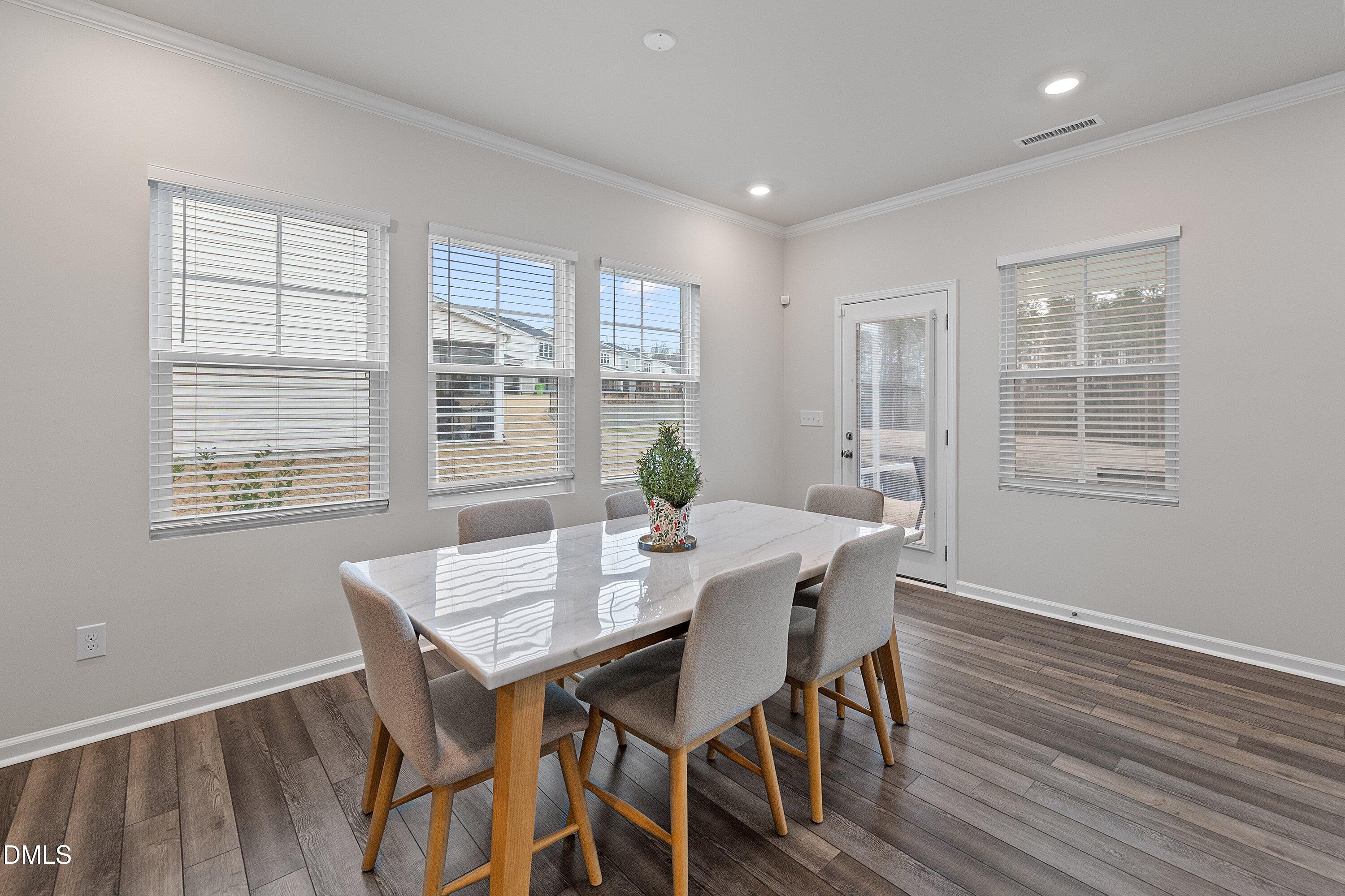 4028 Mount Moran Road Raleigh, NC 27616 - Photo 15 of 46 a view of a dining room with furniture windows and wooden floor