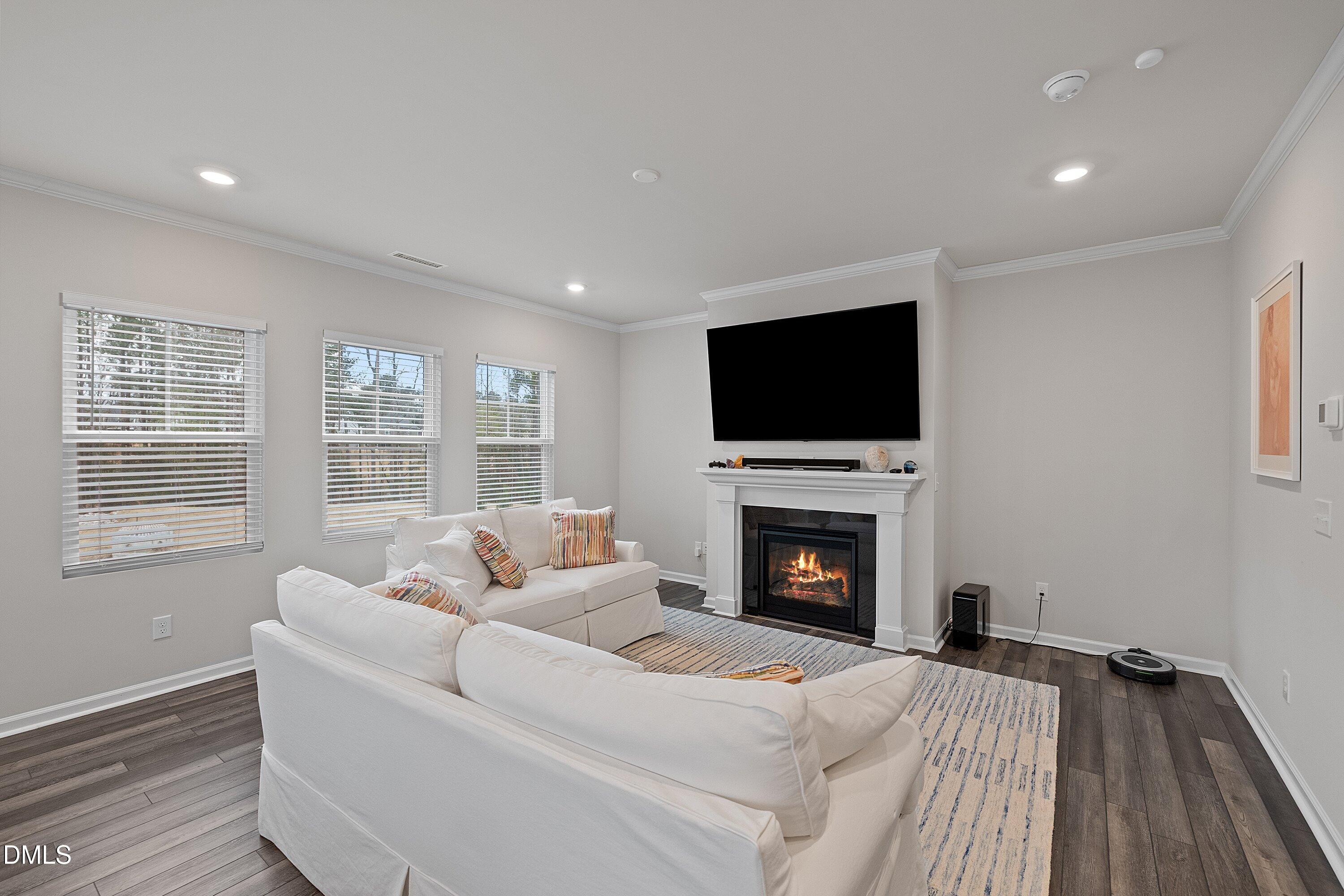4028 Mount Moran Road Raleigh, NC 27616 - Photo 18 of 46 a living room with furniture a fireplace and a flat screen tv