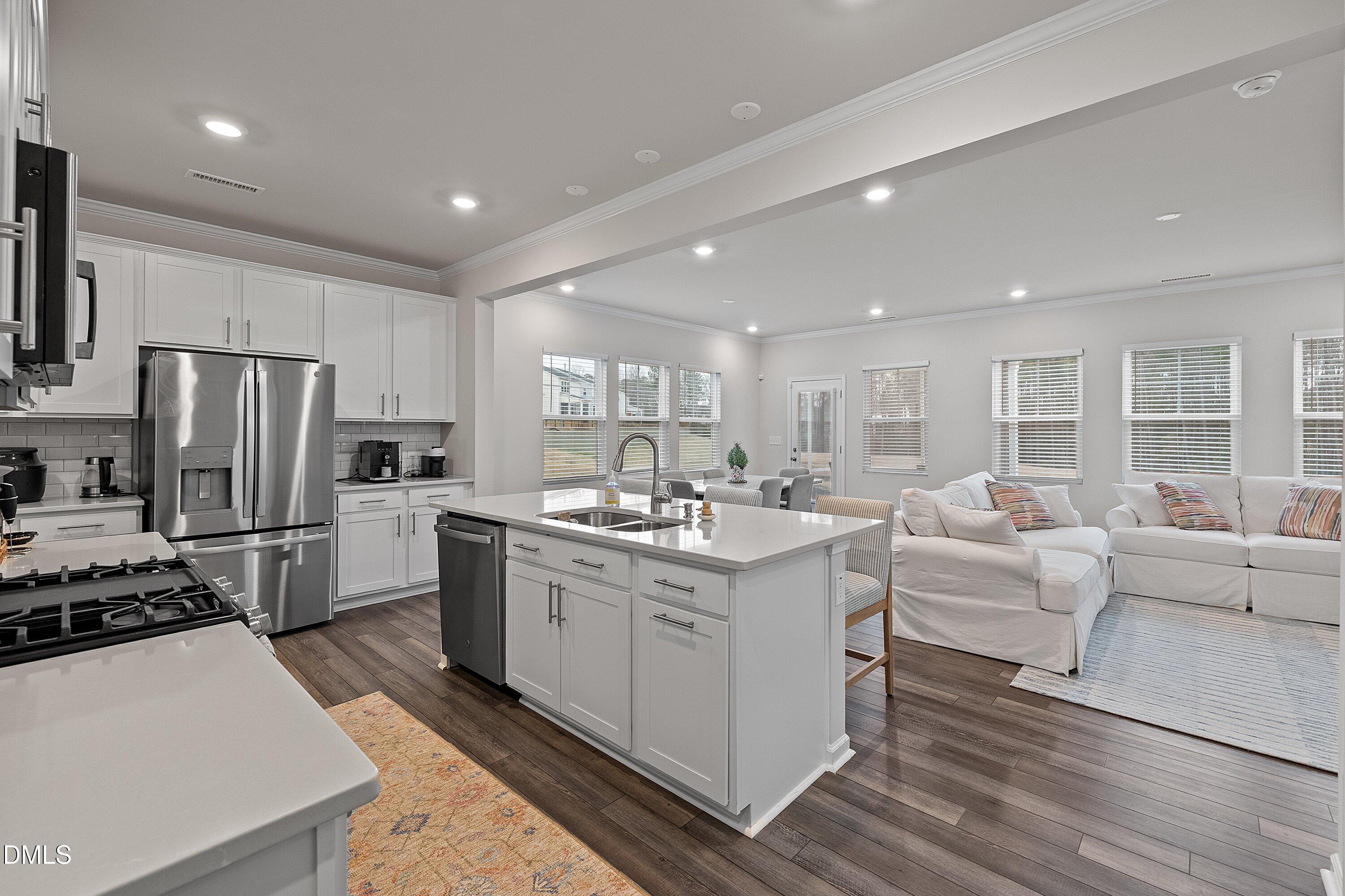 4028 Mount Moran Road Raleigh, NC 27616 - Photo 4 of 46 a kitchen with white cabinets and stainless steel appliances