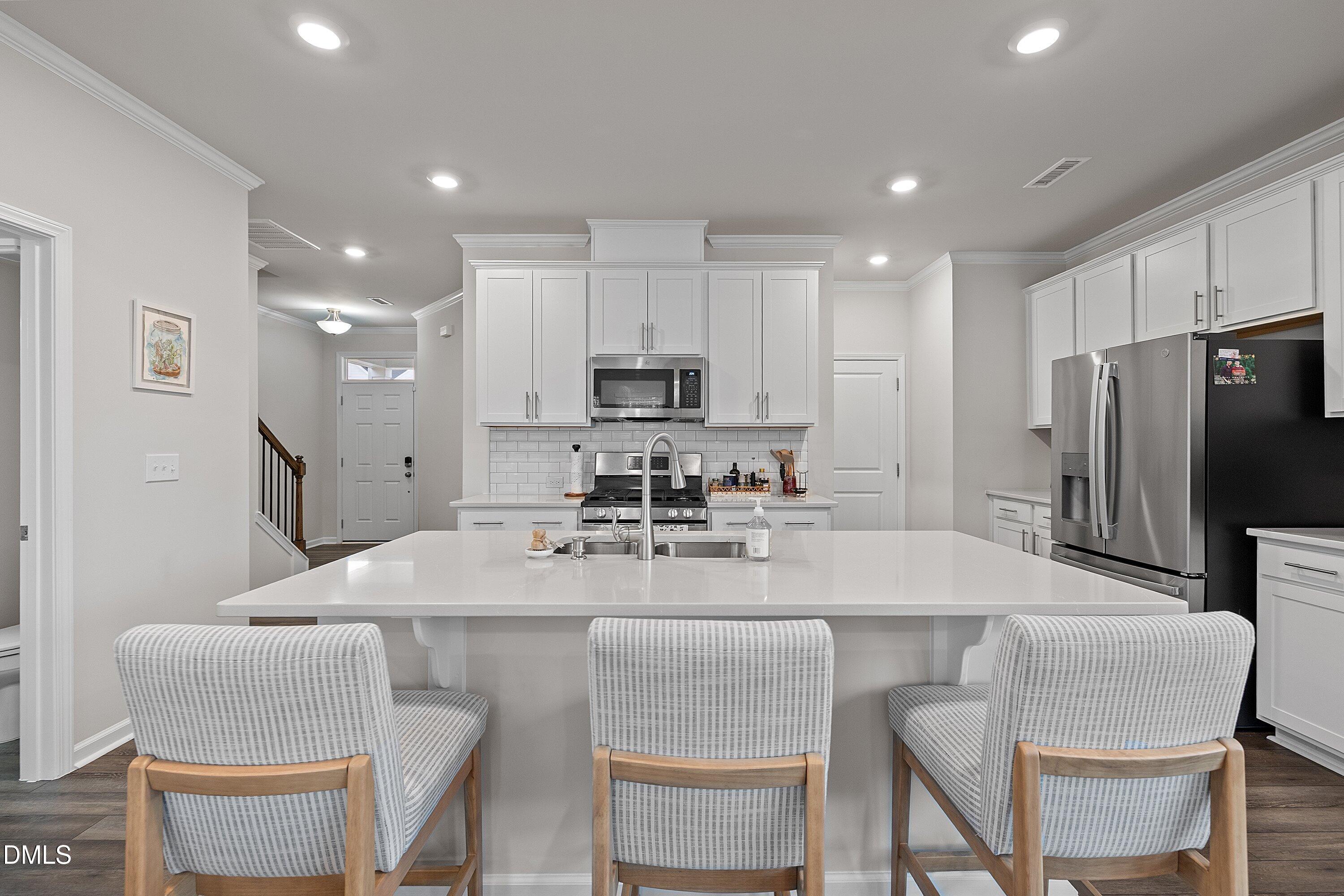 4028 Mount Moran Road Raleigh, NC 27616 - Photo 6 of 46 a kitchen with stainless steel appliances granite countertop a table chairs refrigerator and microwave