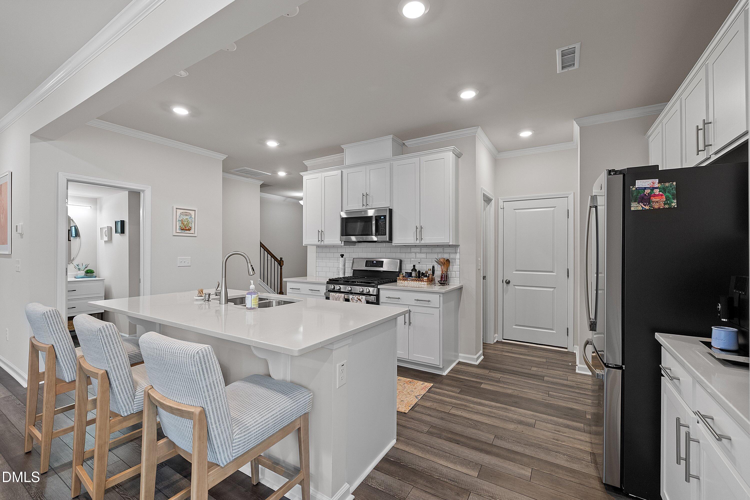 4028 Mount Moran Road Raleigh, NC 27616 - Photo 7 of 46 a kitchen with counter top space a sink appliances and cabinets
