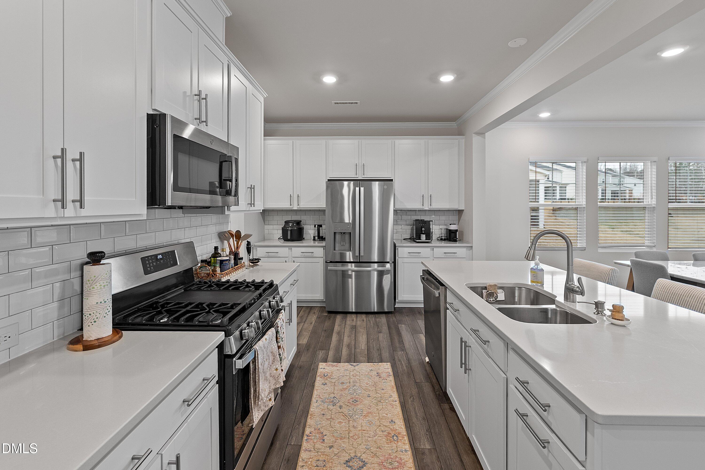 4028 Mount Moran Road Raleigh, NC 27616 - Photo 10 of 46 a kitchen with kitchen island stainless steel appliances a sink stove top oven and refrigerator