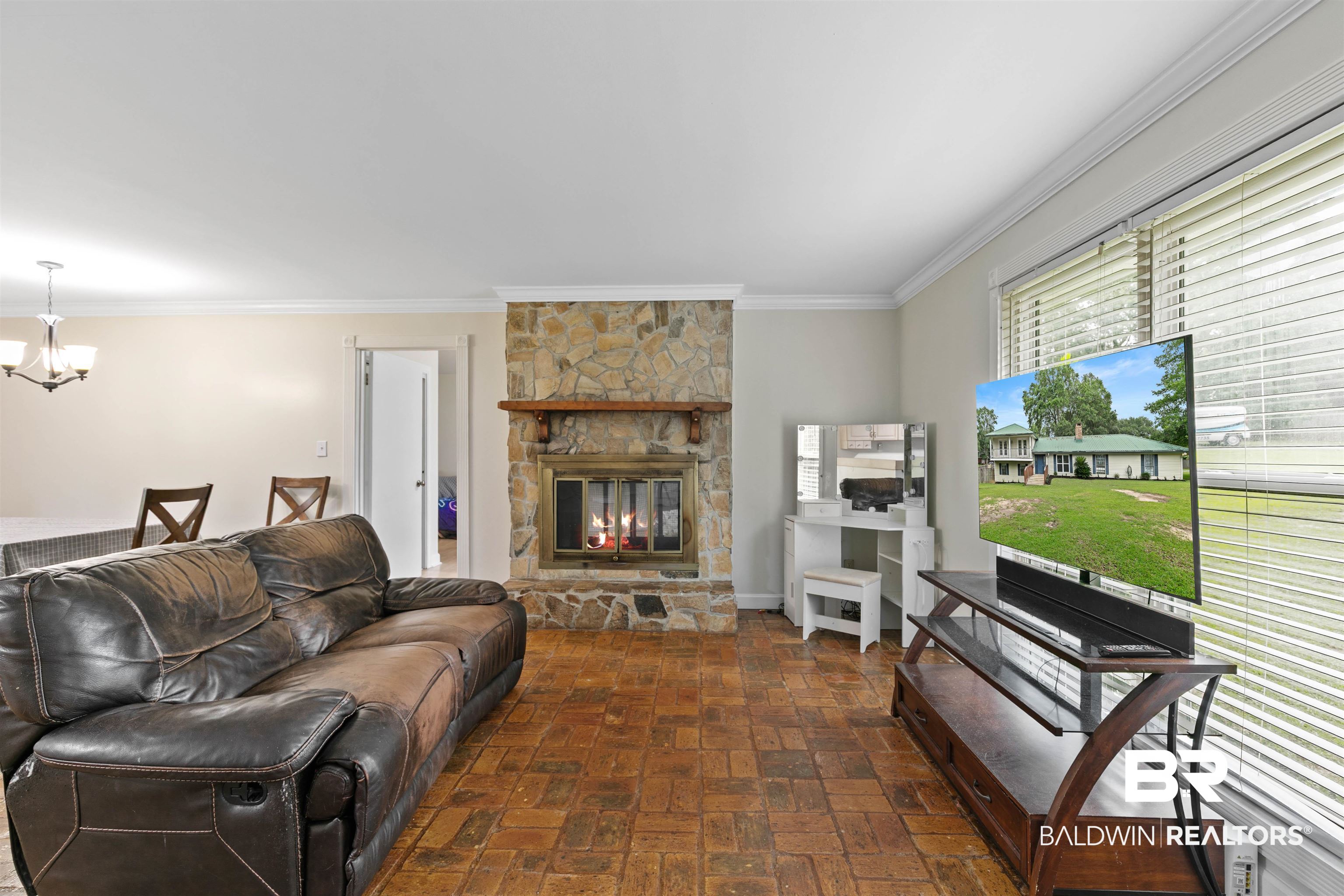 10420 Johnson Road South Mobile, AL 36695 - Photo 16 of 75 Living area featuring a stone fireplace with a wood mantle, brick-finish flooring, and crown molding