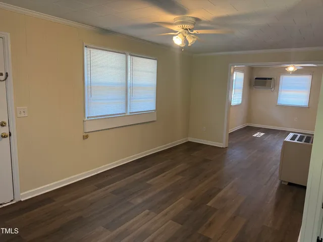 a view of empty room with wooden floor and fan