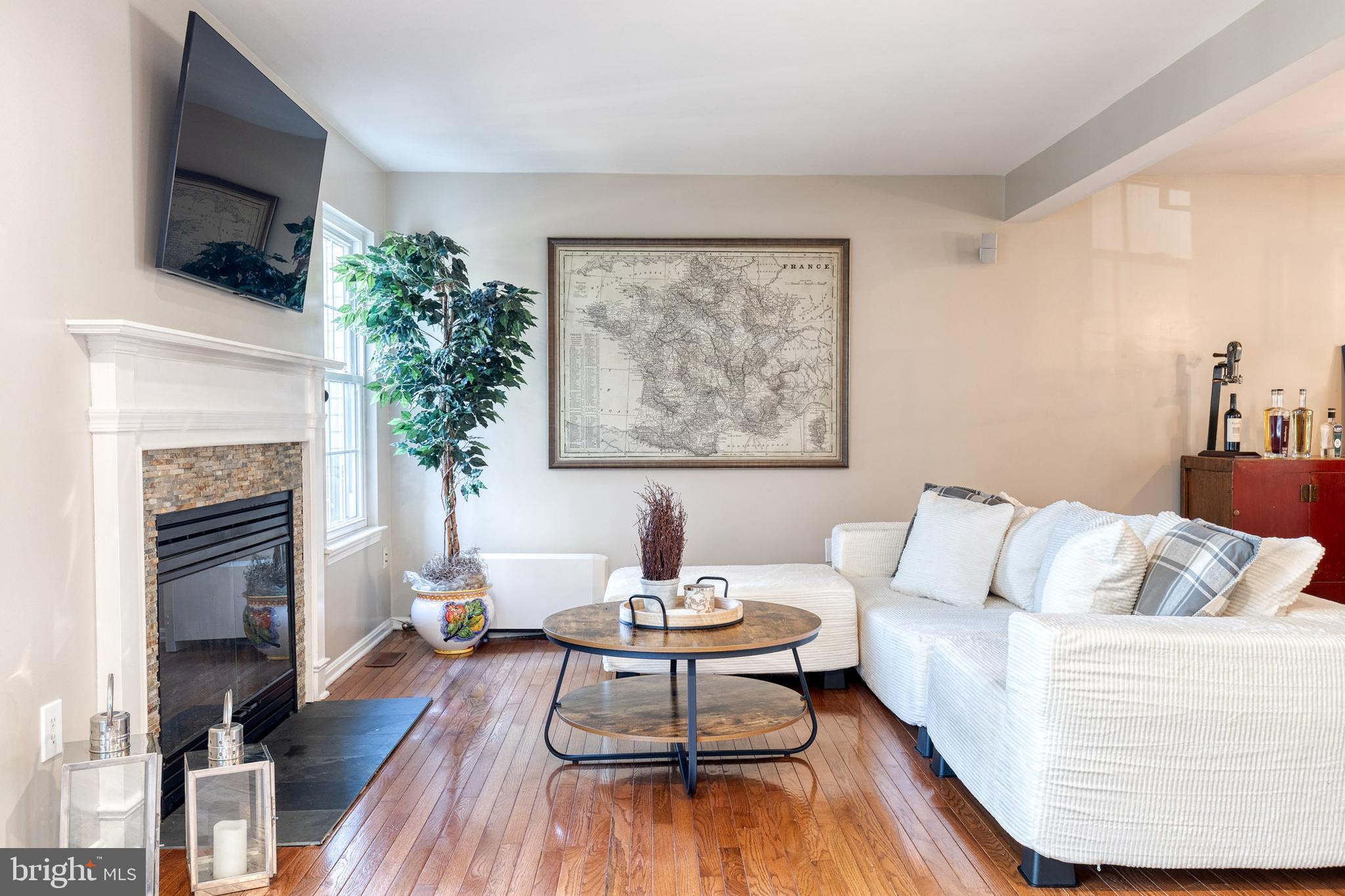 8743 Ruppert Court Ellicott City, MD 21043 - Photo 11 of 41 a living room with furniture a flat screen tv and a fireplace