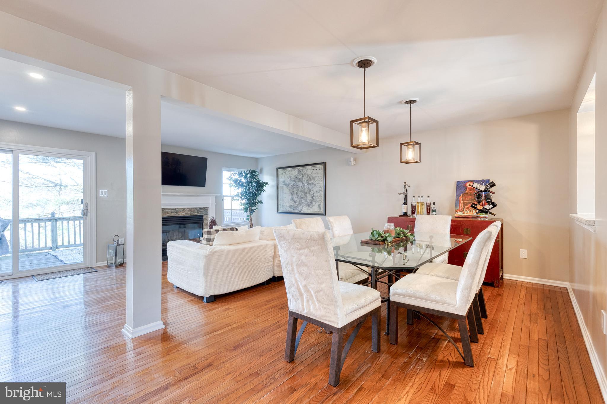 8743 Ruppert Court Ellicott City, MD 21043 - Photo 18 of 41 a dining room with wooden floor a chandelier a glass table and chairs