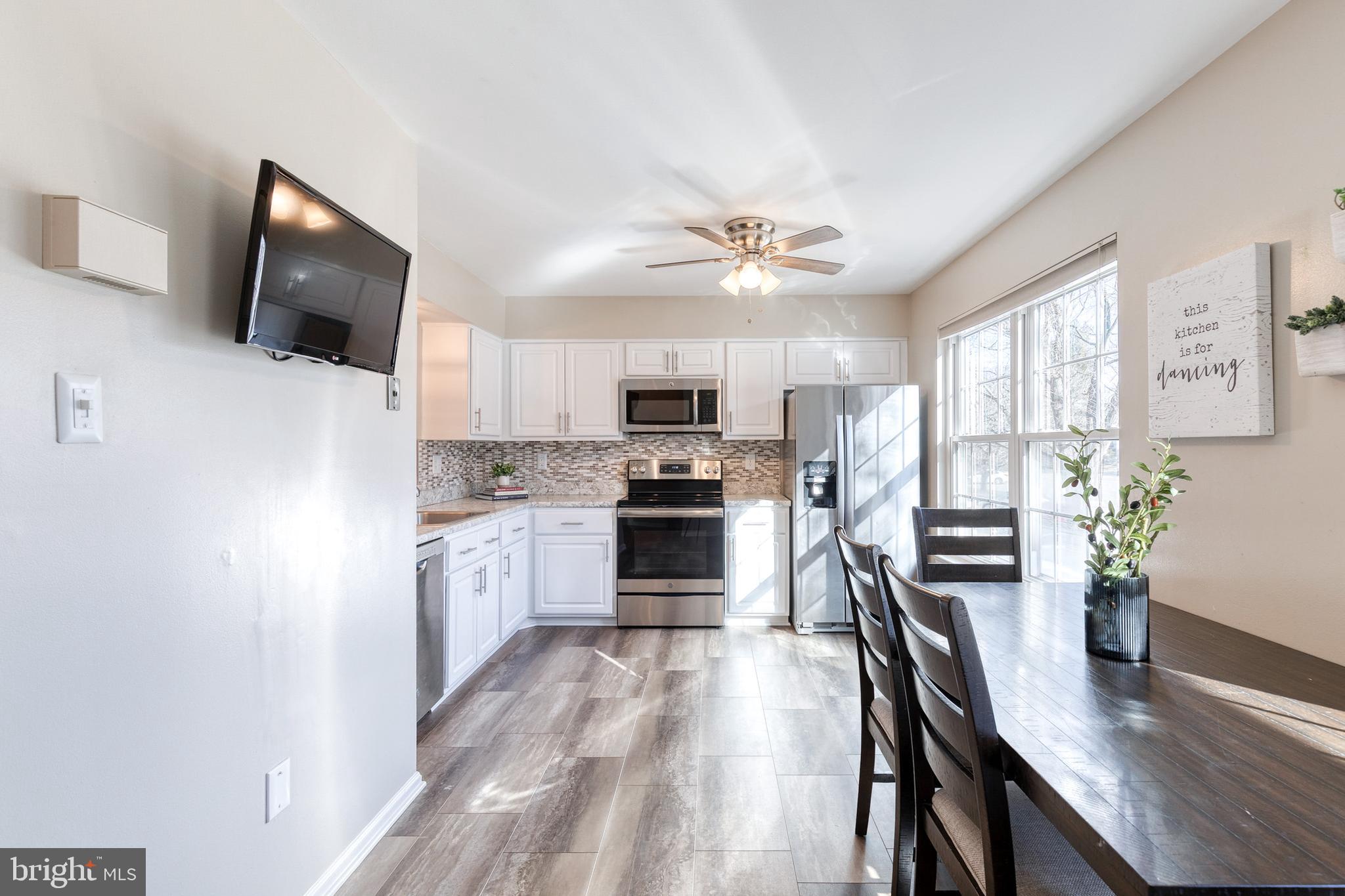 8743 Ruppert Court Ellicott City, MD 21043 - Photo 22 of 41 a large kitchen with cabinets stainless steel appliances a dining table and chairs