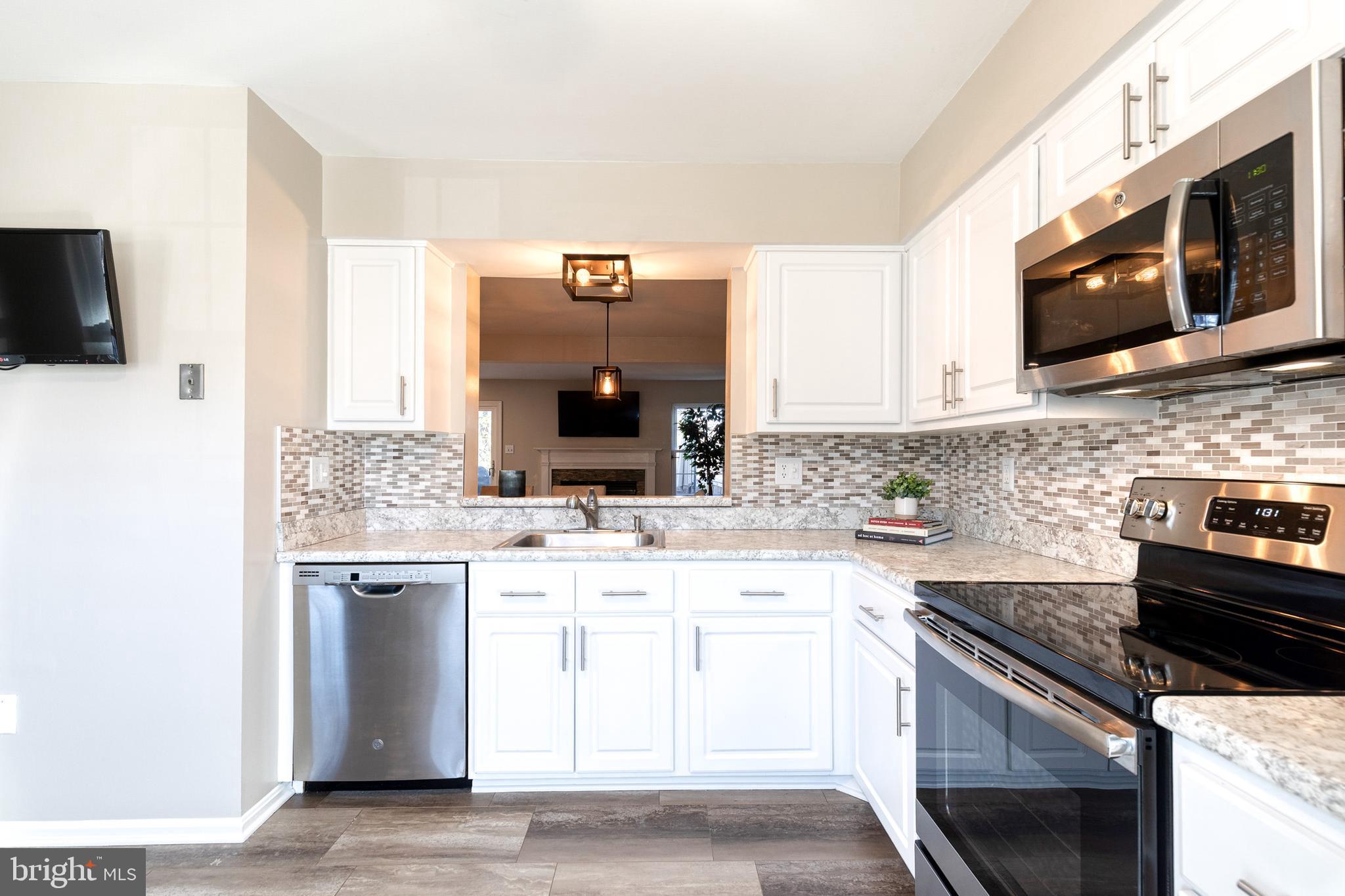 8743 Ruppert Court Ellicott City, MD 21043 - Photo 24 of 41 a kitchen with stainless steel appliances granite countertop a sink and a stove