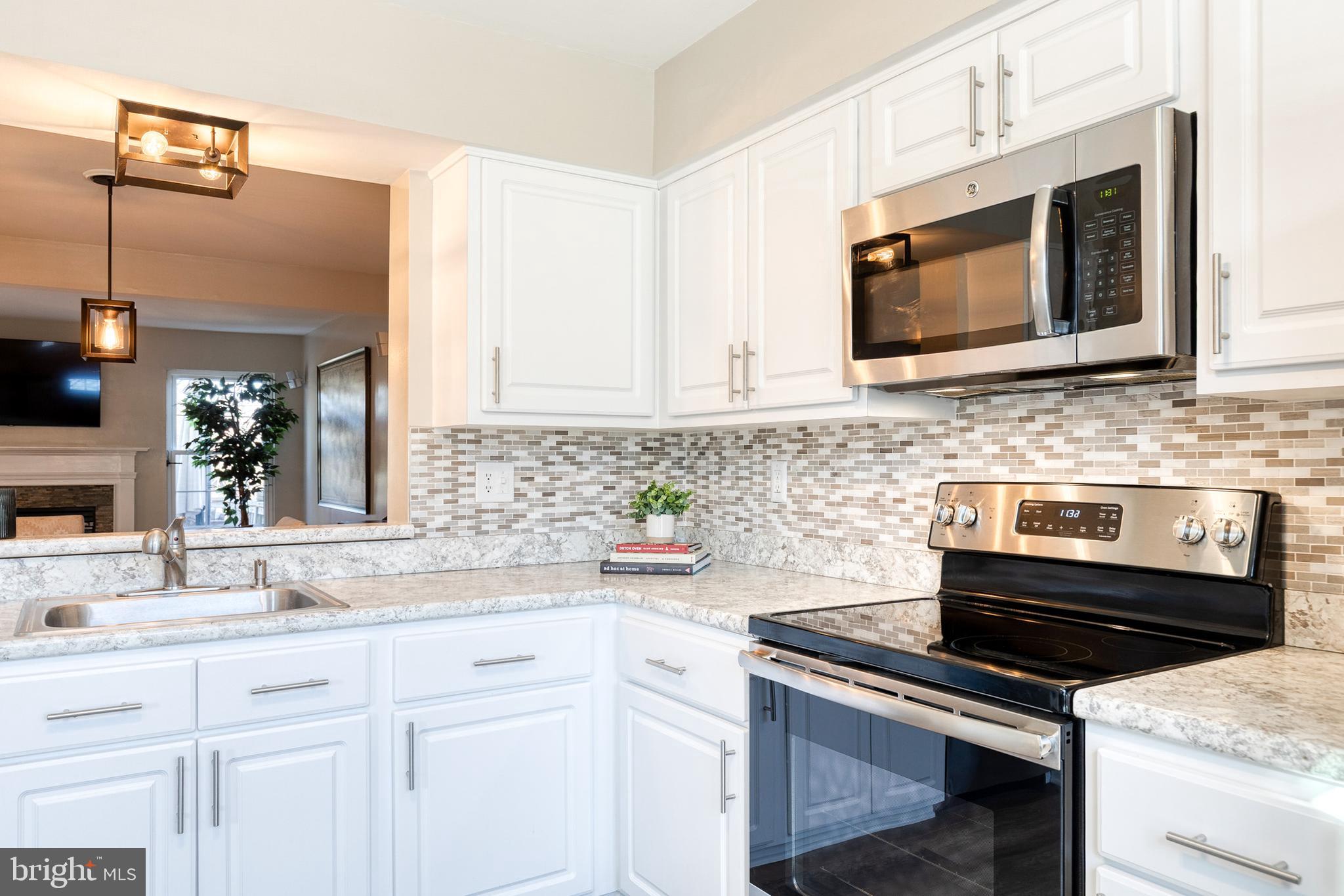 8743 Ruppert Court Ellicott City, MD 21043 - Photo 25 of 41 a kitchen with stainless steel appliances white cabinets and stove