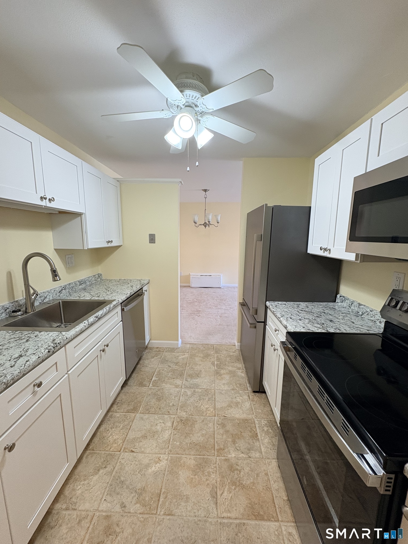 a kitchen with a sink a refrigerator and cabinets