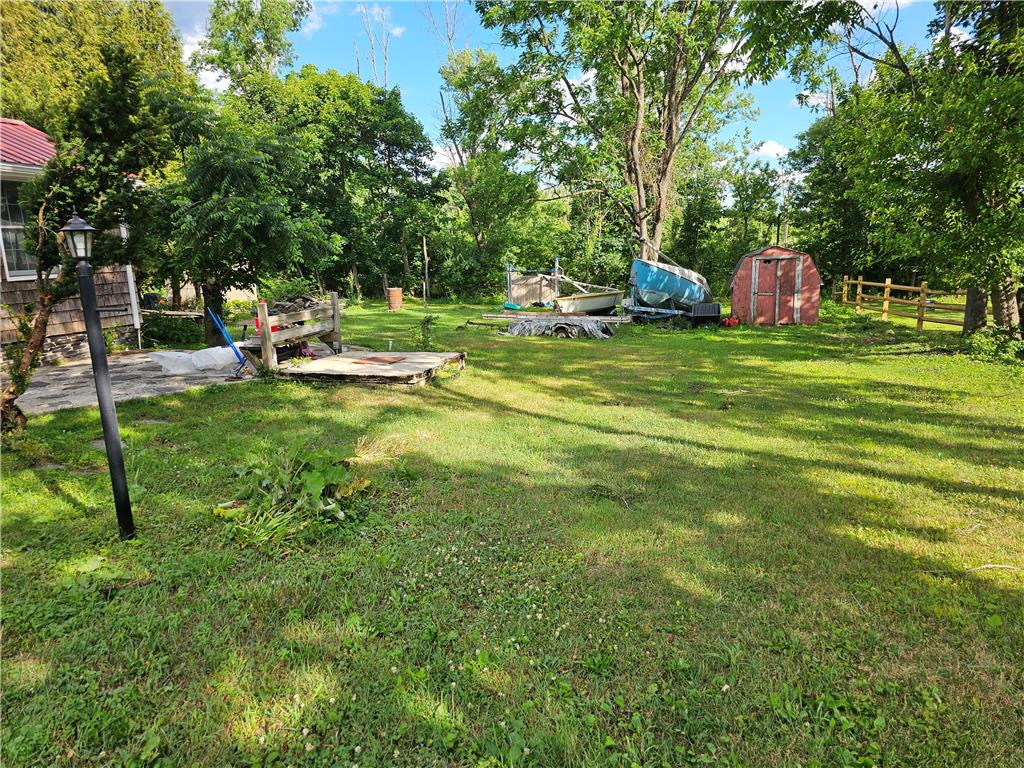 9128 Slateville Road Kempton, PA 19529 - Photo 13 of 13 A generous verdant yard unfolds, dotted with mature trees and a rustic shed.