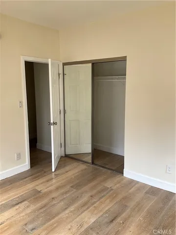 an empty room with wooden floor and closet