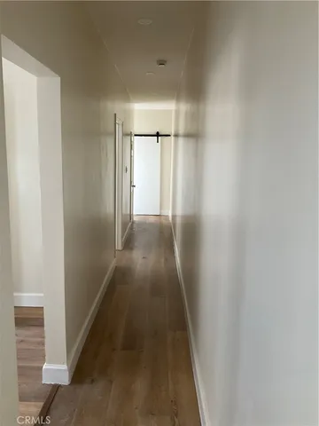 a view of a hallway with wooden floor