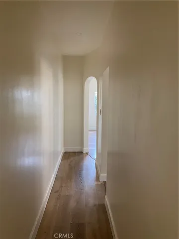 a view of a room with wooden floor and a ceiling fan