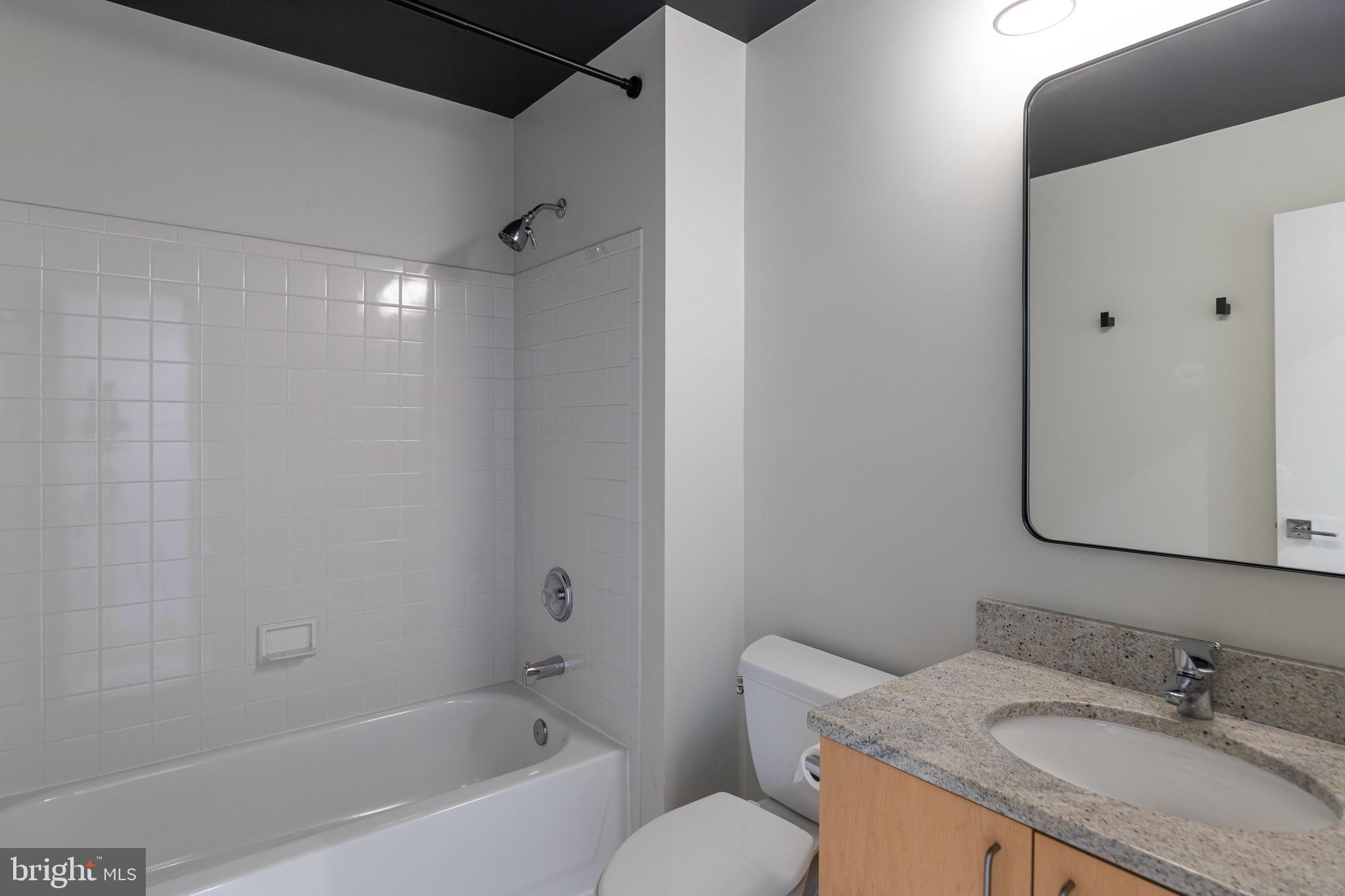 2009 Beacon Place Reston, VA 20191 - Photo 33 of 40 a bathroom with a granite countertop sink toilet and shower