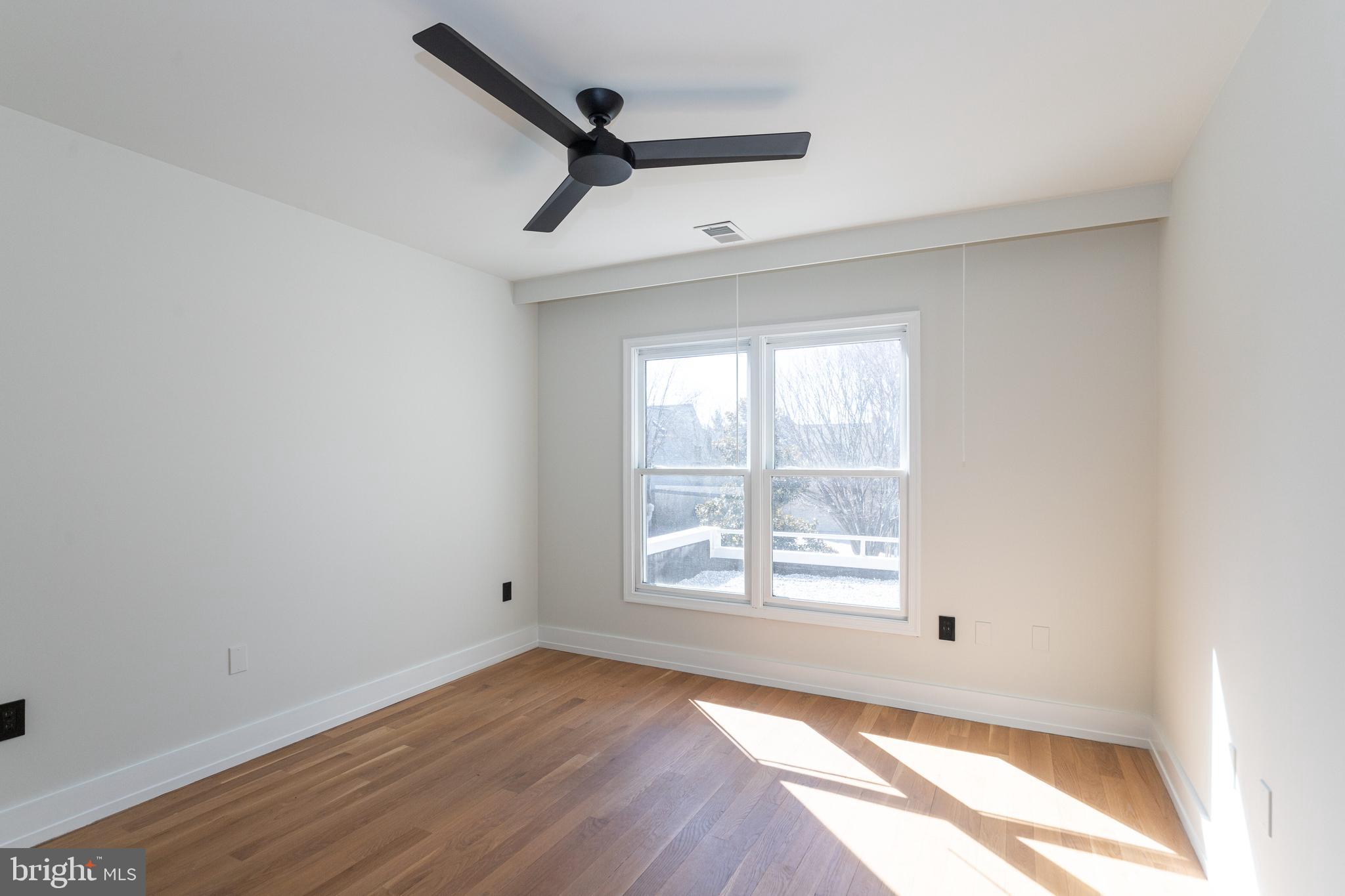 2009 Beacon Place Reston, VA 20191 - Photo 34 of 40 an empty room with wooden floor fan and windows