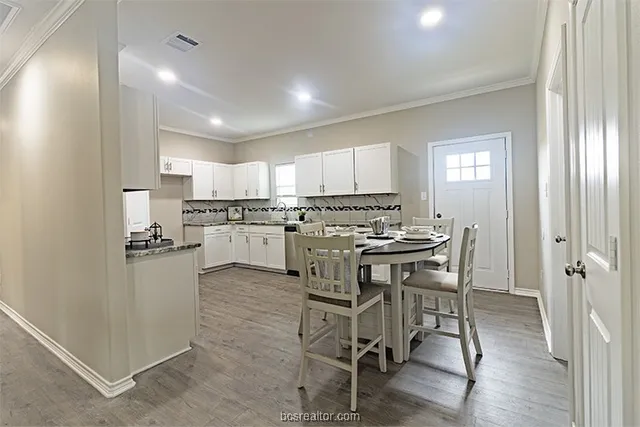 a kitchen with a table chairs refrigerator and cabinets
