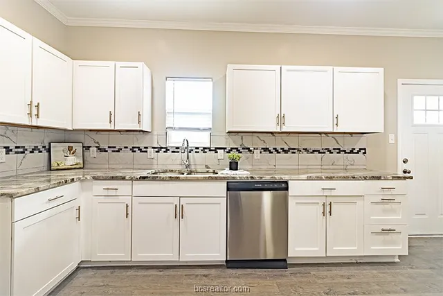 a kitchen with granite countertop white cabinets and white appliances