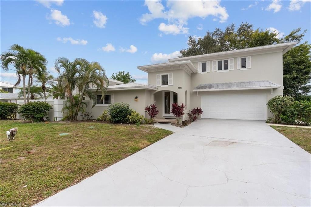 4851 Riverside Drive Estero, FL 33928 - Photo 3 of 35 a view of a white house with a yard and palm trees