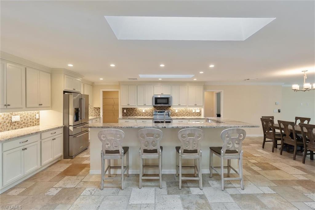 4851 Riverside Drive Estero, FL 33928 - Photo 7 of 35 a large kitchen with a table and chairs