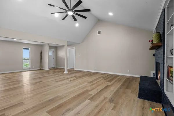 an empty room with wooden floor and entryway