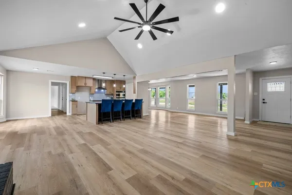 a view of a livingroom with furniture wooden floor and a ceiling fan