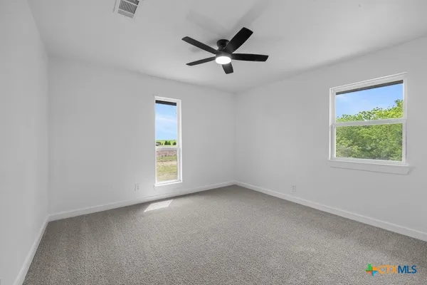 a view of a ceiling fan and a window in a room