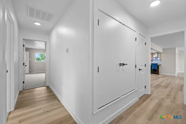 a view of hallway with wooden floor