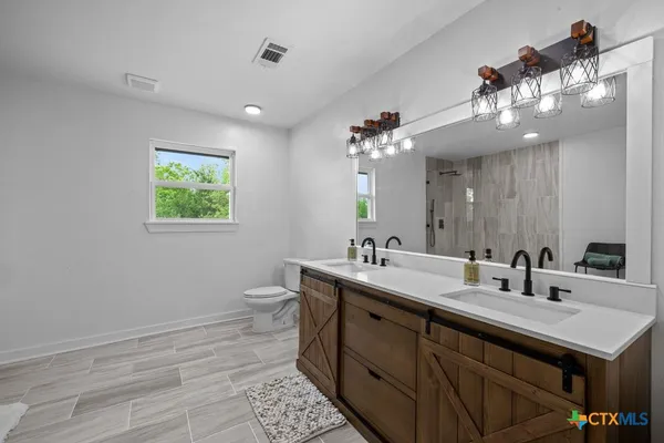 a bathroom with a sink a large mirror and a toilet
