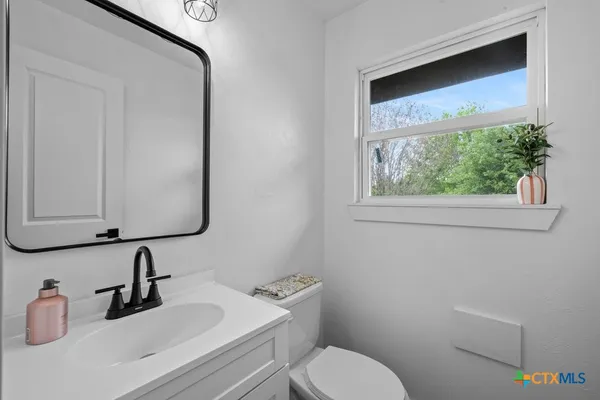 a bathroom with a toilet sink and mirror