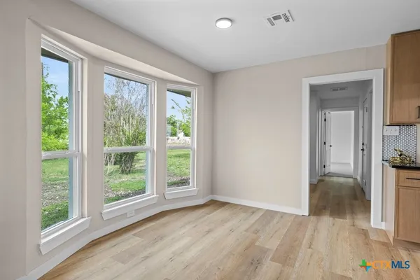 a view of a room that has a bed and wooden floor