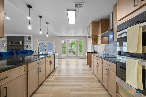 a large kitchen with stainless steel appliances lots of counter space and a sink
