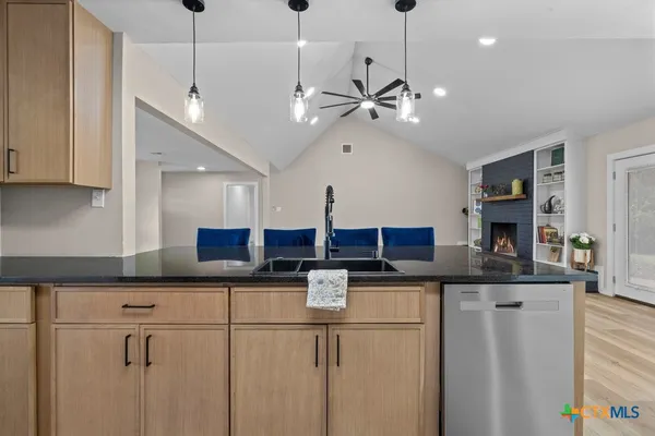 a kitchen with stainless steel appliances granite countertop a sink and a refrigerator