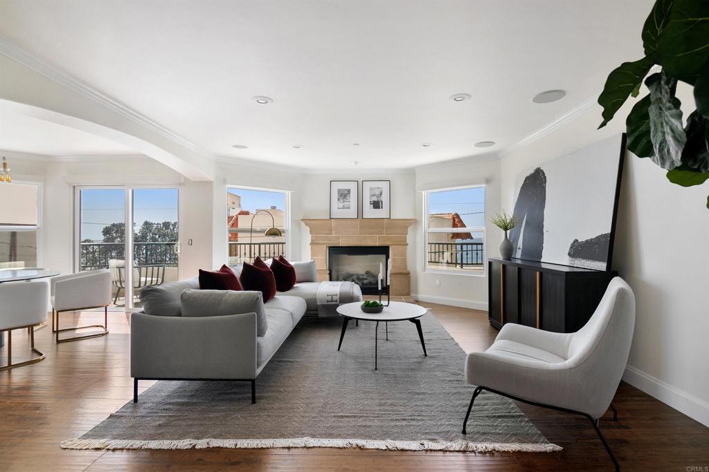a living room with furniture fireplace and a large window