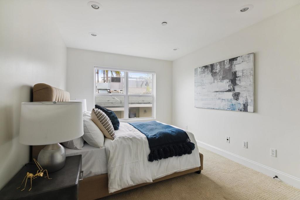 848 Prospect Street, Unit C La Jolla, CA 92037 - Photo 14 of 24 a bedroom with a large bed and a lamp