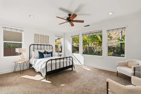 a bedroom with a bed couch and a large window