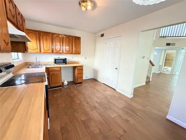 a view of a kitchen with wooden floor and a sink