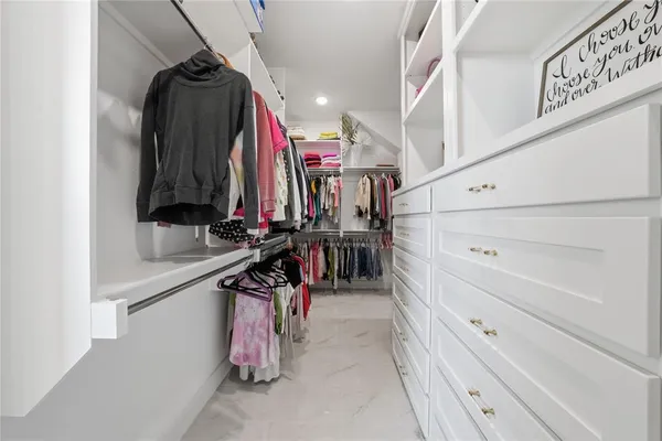 a view of walk in closet with clothes