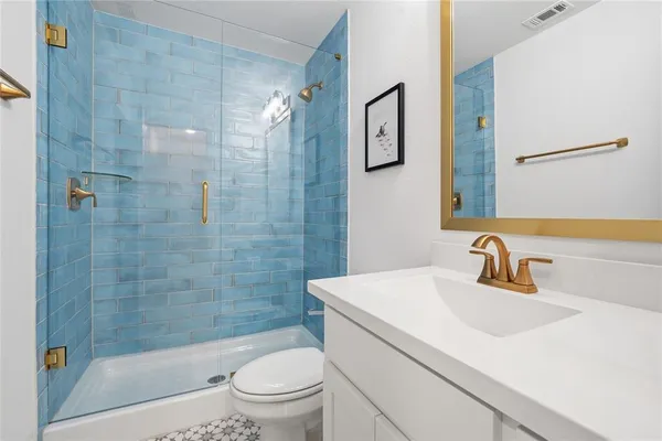 a bathroom with a sink a toilet and shower