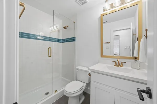 a bathroom with a shower a sink a toilet and mirror