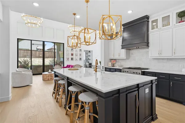 a kitchen with stainless steel appliances granite countertop a sink a stove and a wooden floors