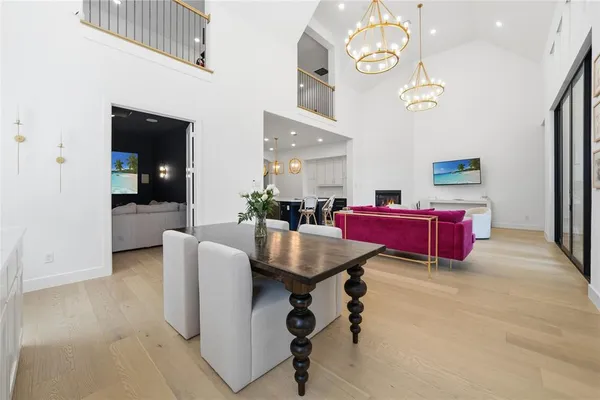 a living room with couches and kitchen view with wooden floor