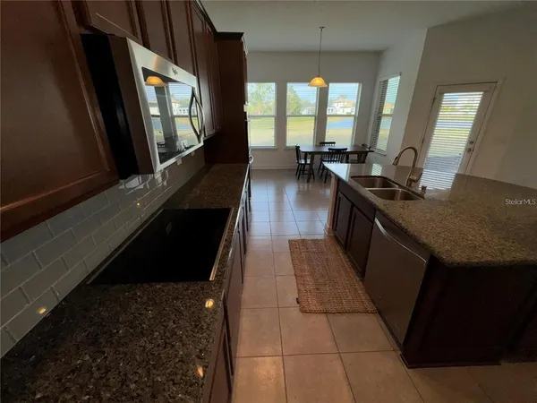 a kitchen with granite countertop sink stove and cabinets