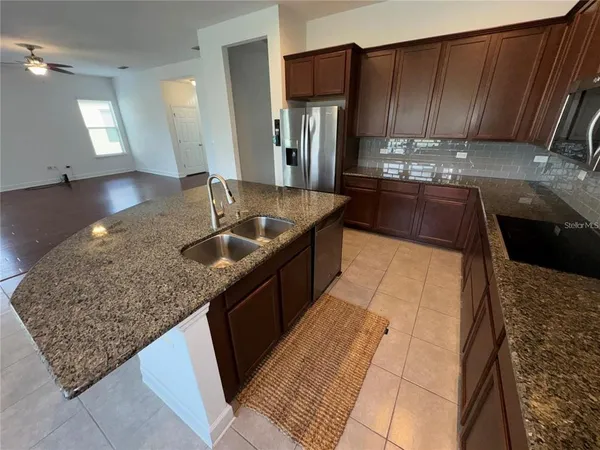 a kitchen with kitchen island granite countertop a sink dishwasher stove and cabinets