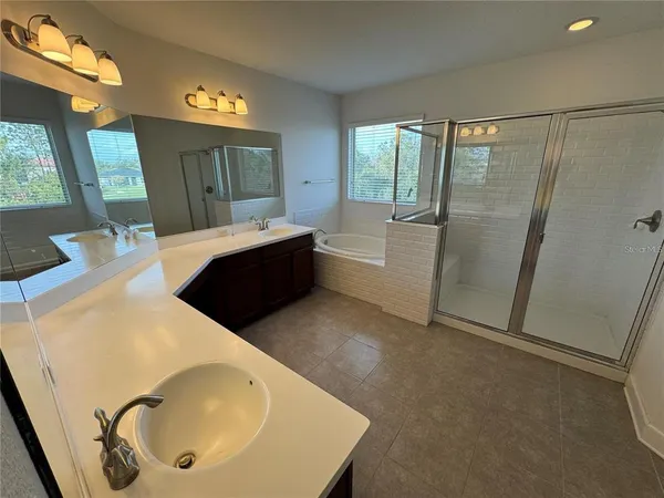 a bathroom with a tub sink and mirror